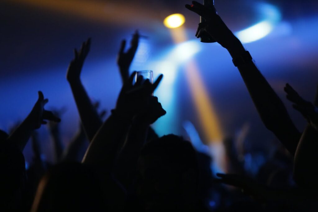 Vibrant nightlife scene with silhouettes of partygoers dancing under colorful lights, capturing the energy and excitement of a celebration.