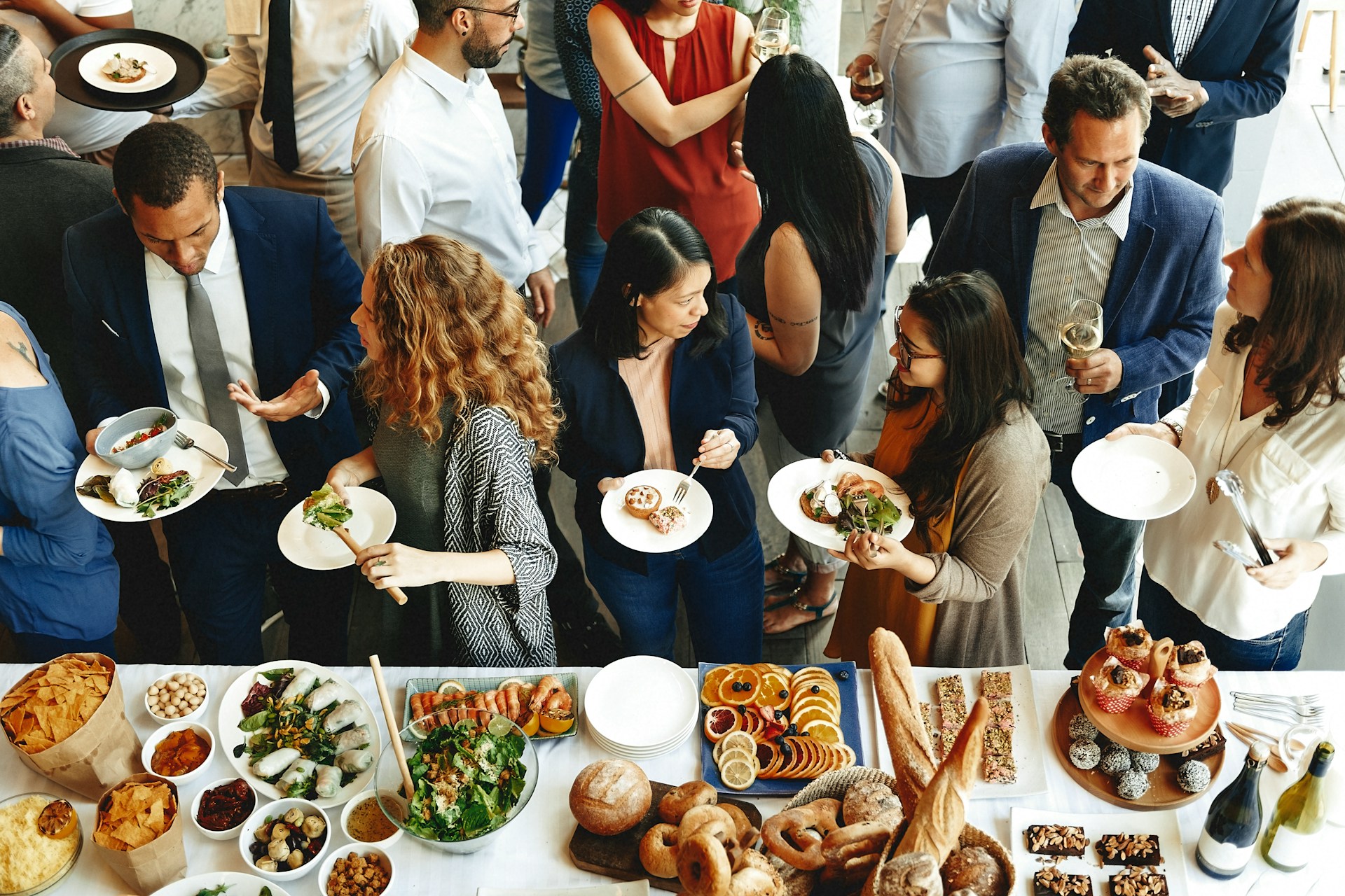 A lively corporate event with professionals networking and enjoying a buffet-style meal, the perfect occasion to arrive in style with a Party Bus Budapest.