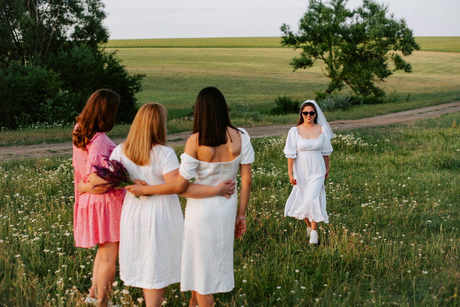 A cheerful bride-to-be celebrating a hen party in a scenic field, perfect for pairing with the elegance of the Pink Hummer Limousine Budapest.