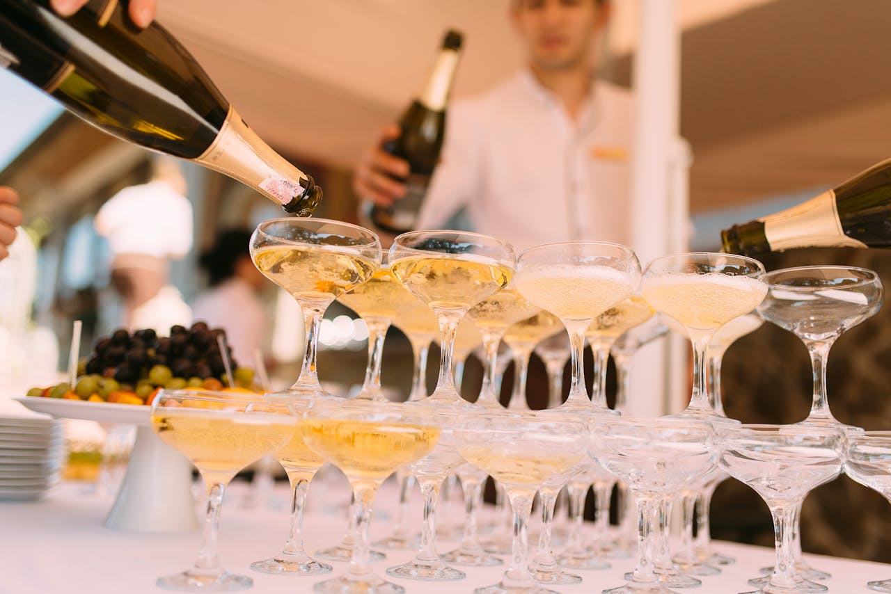 Elegant champagne glasses being filled at a gala event, perfectly complemented by the luxurious arrival in a Hummer Limousine Budapest.