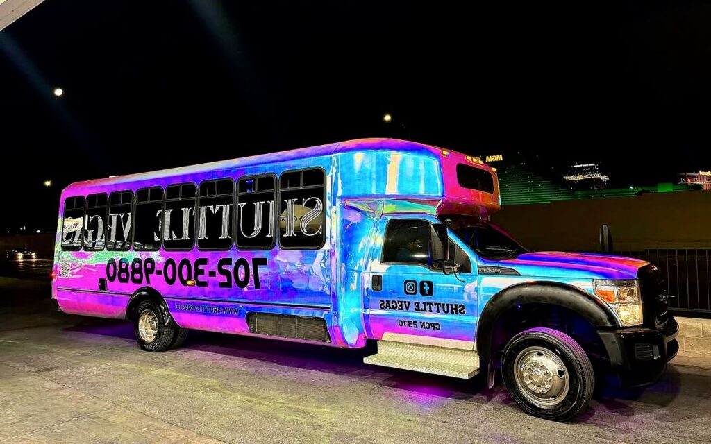 Colorful party bus in Budapest at night with neon lights on the exterior, representing the energetic vibe of group celebrations.