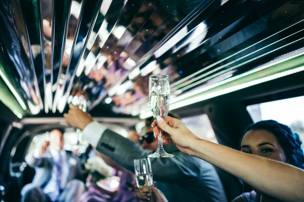People raising champagne glasses inside a Hummer limousine in Budapest, showing the luxury interior with lights and celebration atmosphere.