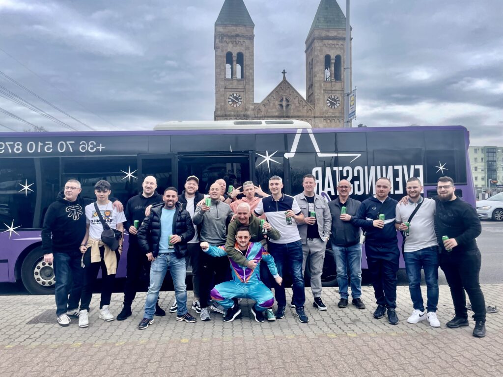 Large group of people posing in front of a purple party bus in Budapest, ideal for team events and celebrations with 30 or more passengers
