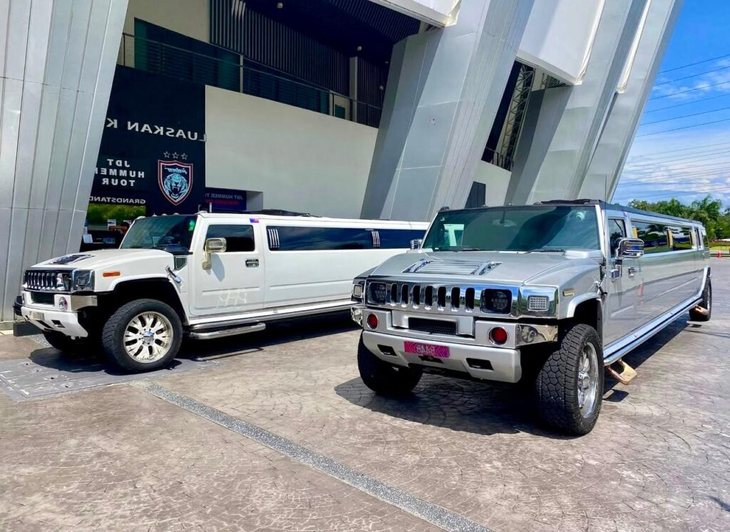 White and grey Hummer limousines parked side by side in Budapest, showing stylish and maneuverable luxury vehicles.