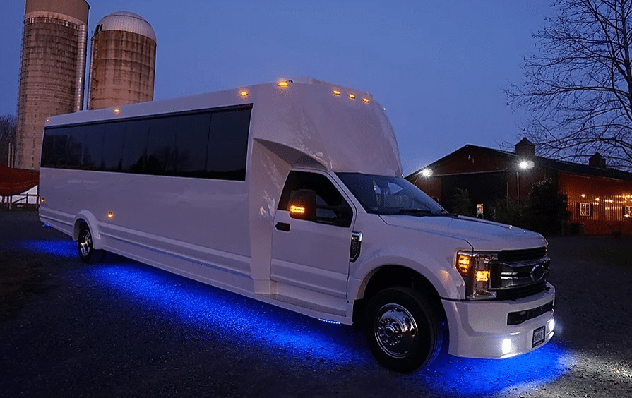 White party bus in Budapest at night with glowing blue lights, designed for large groups and nightlife celebrations.