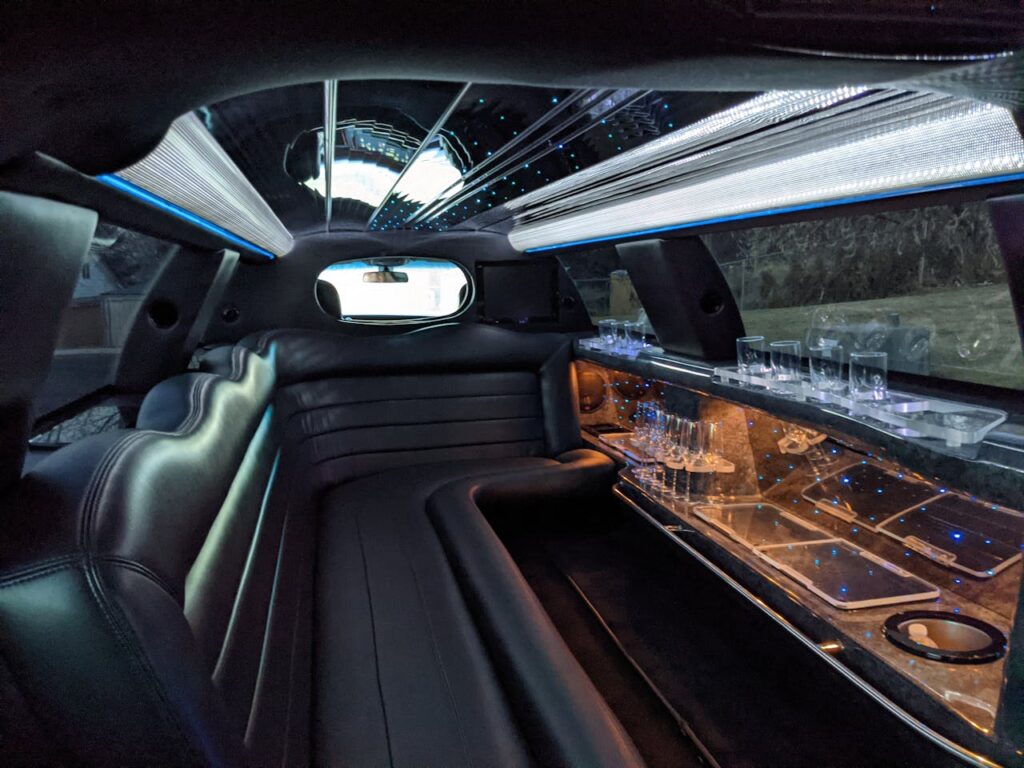 Standard Hummer limo interior in Budapest with leather seating, LED ceiling lights and a built-in bar.