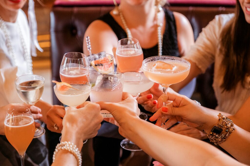 Friends toasting with colorful cocktails during a celebration in Budapest.