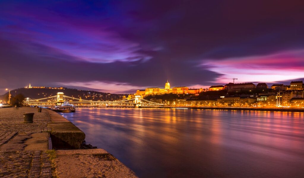 Hidden Budapest photo spots limo tour across Chain Bridge with illuminated Buda Castle at night