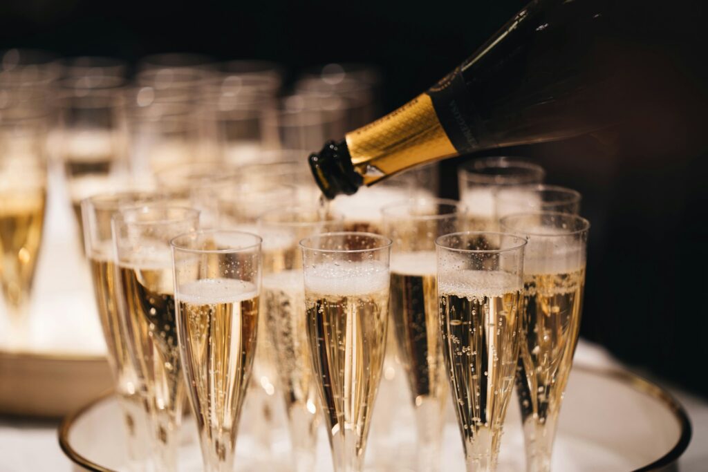 Close-up of champagne being poured into elegant flutes during a luxury limousine service in Budapest — symbolizing celebration, premium comfort, and the exclusive atmosphere of the limousine services Budapest experience.