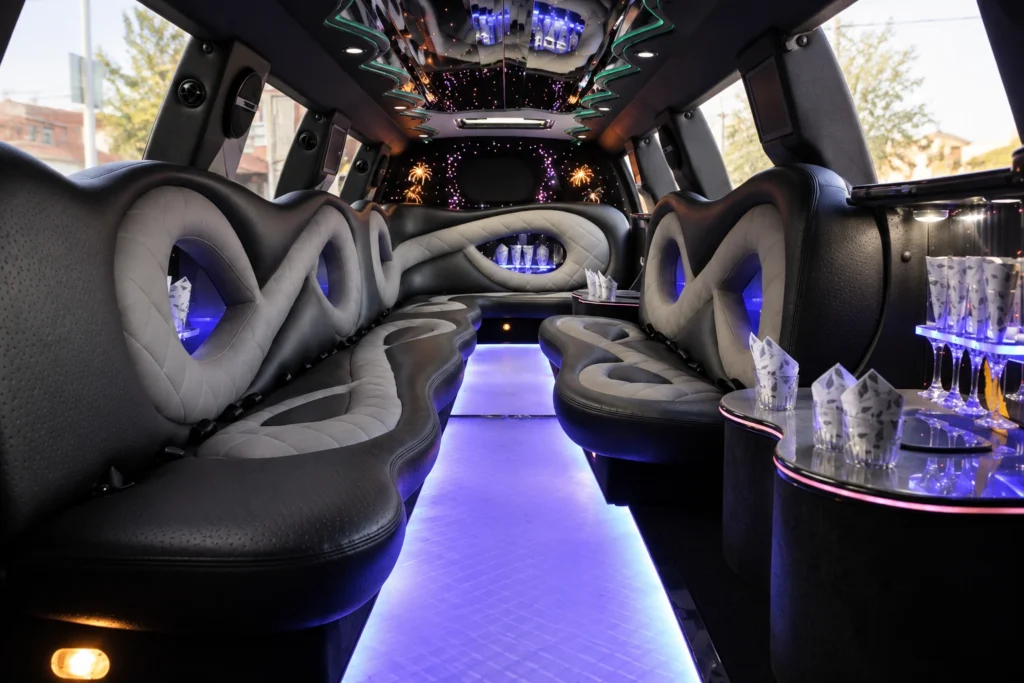 Lincoln Navigator limo interior with black and grey leather seating and an illuminated central aisle.